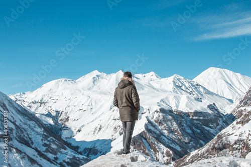 The man looks at the beautiful mountains in winter in Georgia