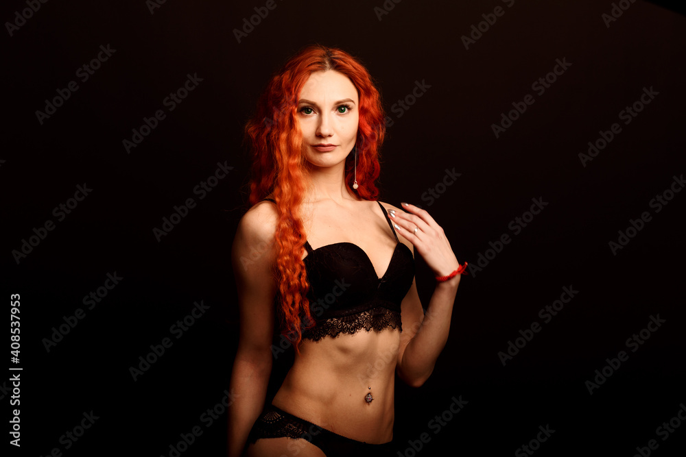Fototapeta premium Sexy woman in lingerie in black background, red hair