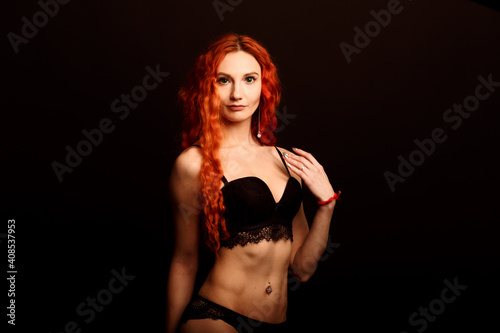 Sexy woman in lingerie in black background  red hair