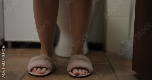 Woman legs sit down on the toilet and down her panties