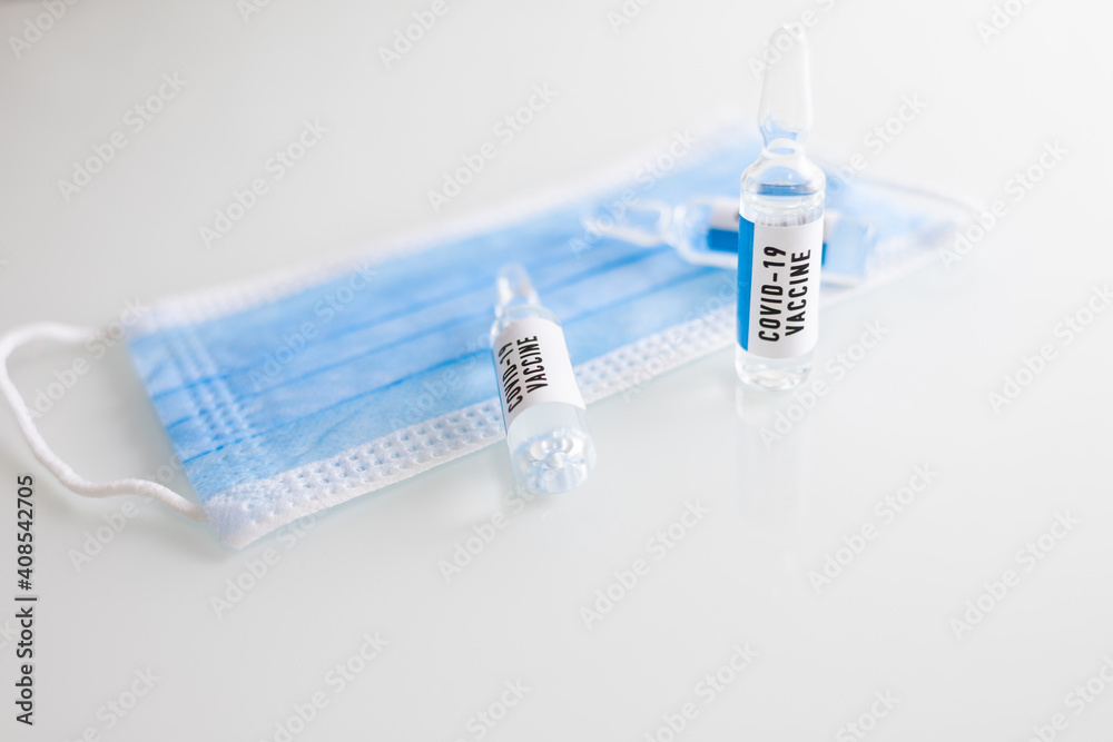 Vials of COVID-19 vaccines are placed on a medical mask