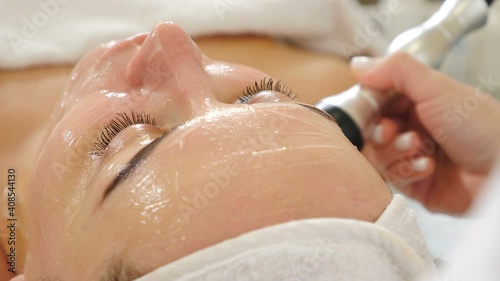 RF lifting procedure. Young woman getting stimulating beauty facial treatment. machine cosmetology in modern spa salon. biolifting rejuvenating antiaging skin care. 4 k video