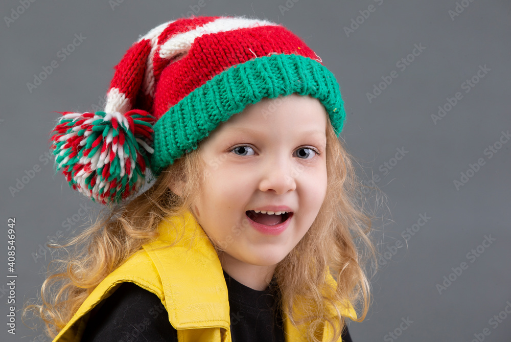 Funny little girl in a Christmas hat. Portrait of a cheerful and happy child. Funny little girl in a Christmas hat. Portrait of a cheerful and happy child.