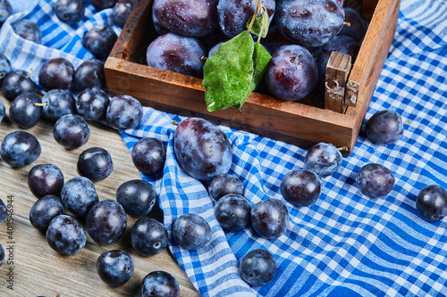 Garden plums scattered through wooden table