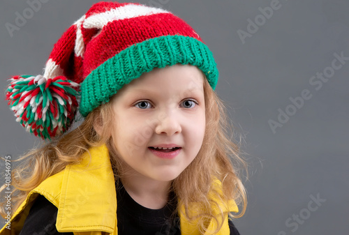 Funny little girl in a Christmas hat. Portrait of a cheerful and happy child.