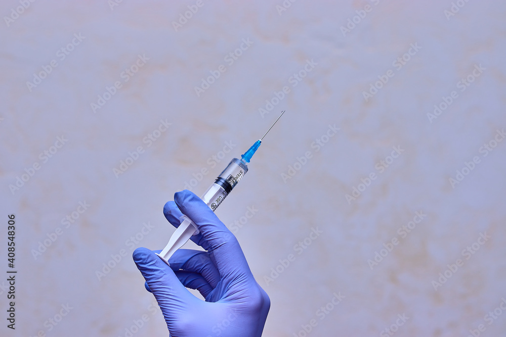 Vaccination. Syringe with a vaccine in doctor's hand. Hand in medical gloves holding a syringe. Vaccination. Syringe with a vaccine in doctor's hand. Hand in medical gloves holding a syringe.