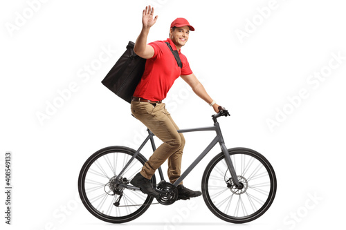 Food delivery man in a red t-shirt delivering food with a bicycle and greeting with hand