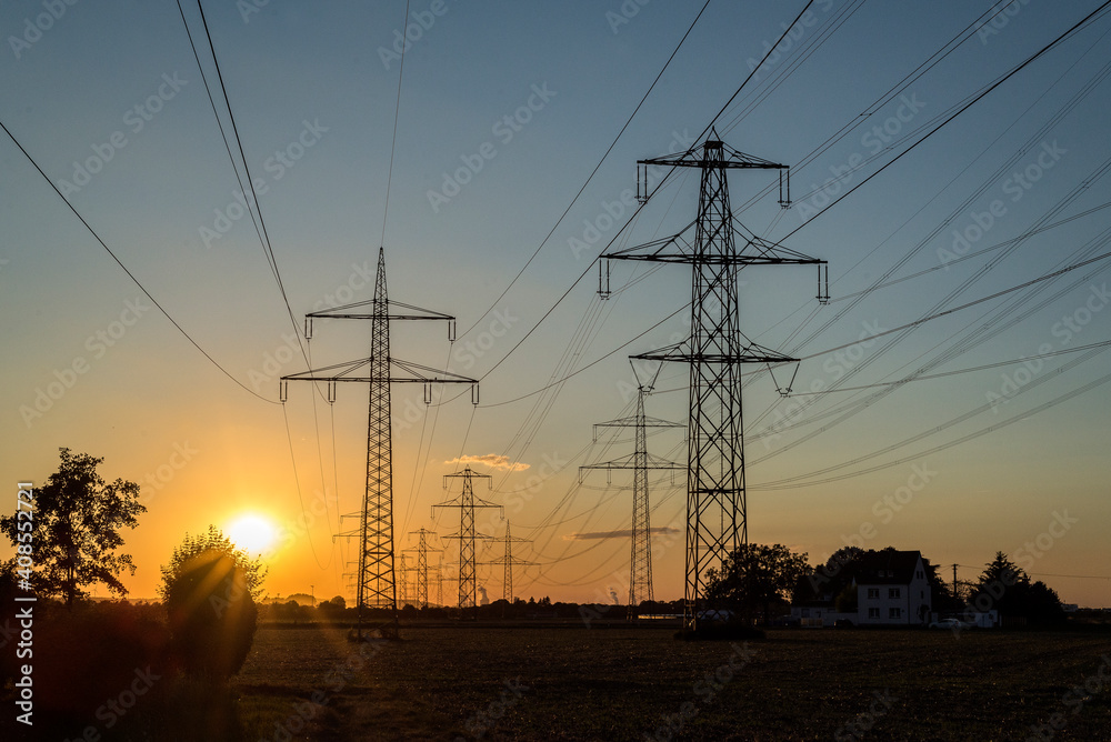 Fototapeta premium Starkstrommasten im Sonnenuntergang