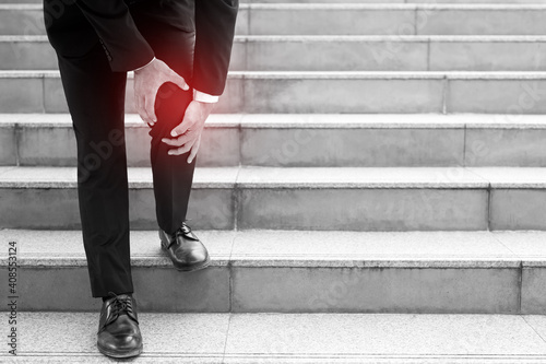 Tapet Businessman in a suit have the sore pain and painful knee problem expression and walk up and down on the stairway during go to office