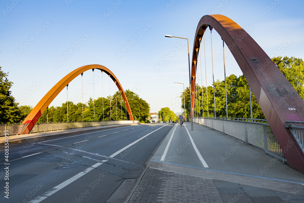 Fototapeta premium Bogenbrücke mit Straße in abendlicher Stimmung
