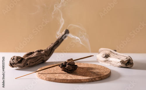 Burning aromatic incense smoky stick for meditation and relaxing on wooden minimalistic background. Aromatherapy smoke for yoga concept. photo