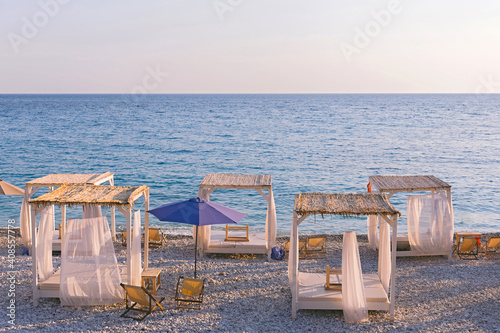 Beautiful canopies or baldachine at sea beach at the sunset. Vacation and relaxation concept. photo