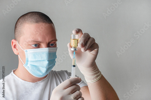 Concept fight against virus covid-19 corona virus, doctor or nurse or scientist in laboratory holding a syringe with liquid vaccines. 