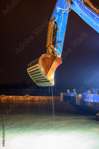 Fotografie boom of a dredger with special shovel for deepen the riverbed in the guest harbo