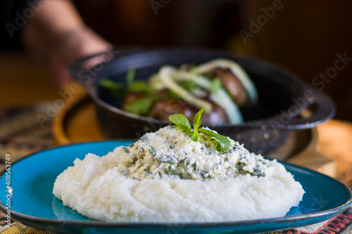 Georgian traditional food and cuisine Ghomi with cheese and red wine. Cornmeal. photo