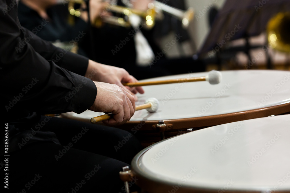 Naklejka premium Hands of a musician playing the timpani in the orchestra close up