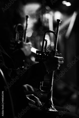 Foto Silhouette of a trumpet in the hands of a musician in an orchestra in dark color