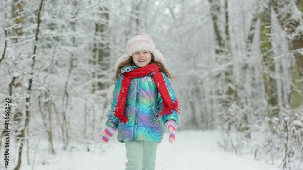 Funny laughing child girl running in a beautiful snowy park. Happy girl playing on a winter walk in nature. Expressing positivity, true brightful emotions, smiling Funny laughing child girl running in a beautiful snowy park. Happy girl playing on a winter walk in nature. Expressing positivity, true brightful emotions, smiling