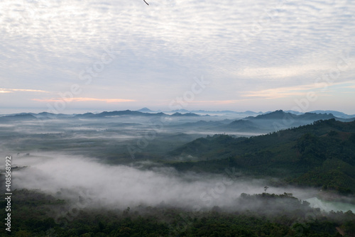 Natural landscape scenery from peak of green mountains in the misty fog with sunrise sky in Thailand for travel attraction concept