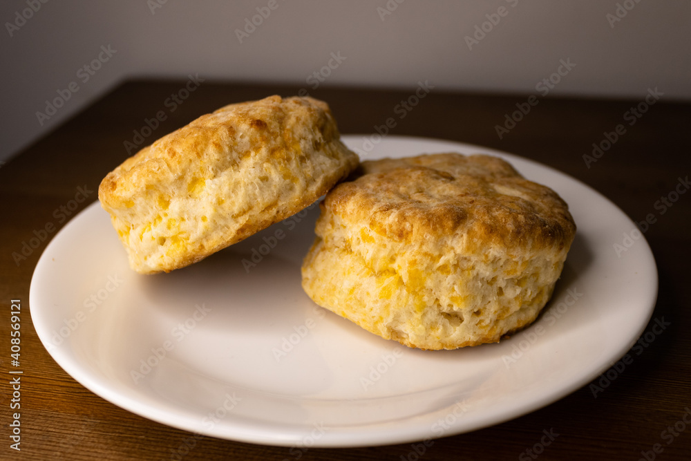 Two cheese biscuits isolated on a white plate. Two cheese biscuits isolated on a white plate.