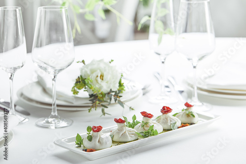 Fresh burata cheese with tomatoes and herbs on white plate