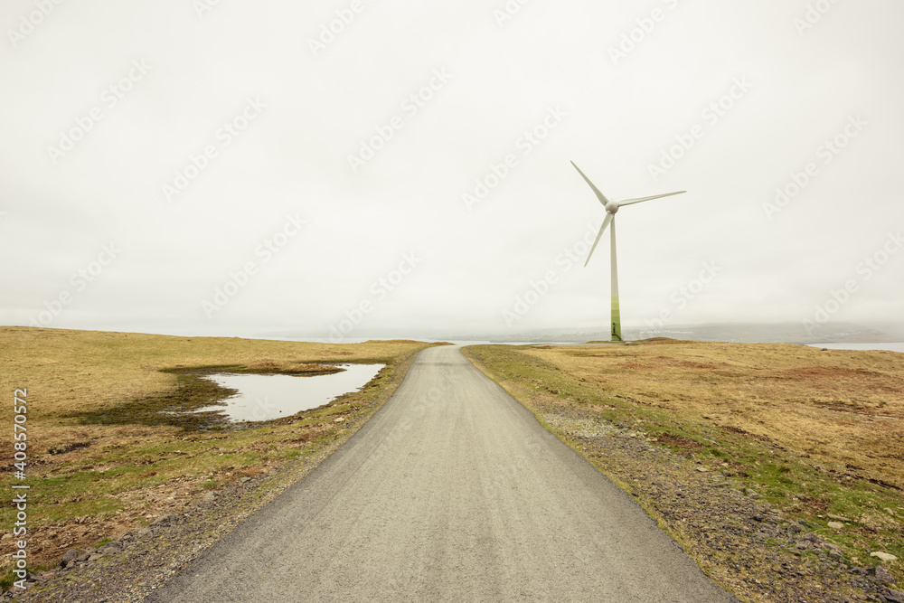 Road and windmill against gray sky Road and windmill against gray sky