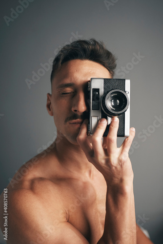 Retro de un chico moreno with bigote with analogical camara