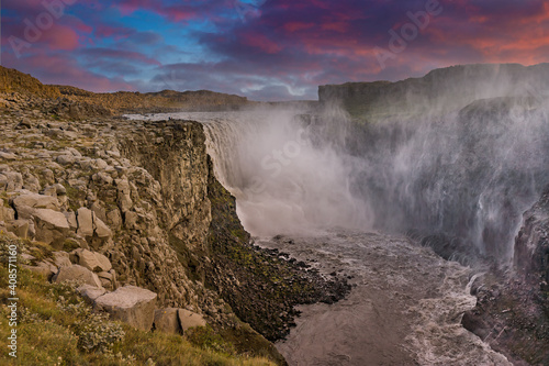 Iceland. Dramatic waterfall surrounded by dark basalt lava hexagonal columns