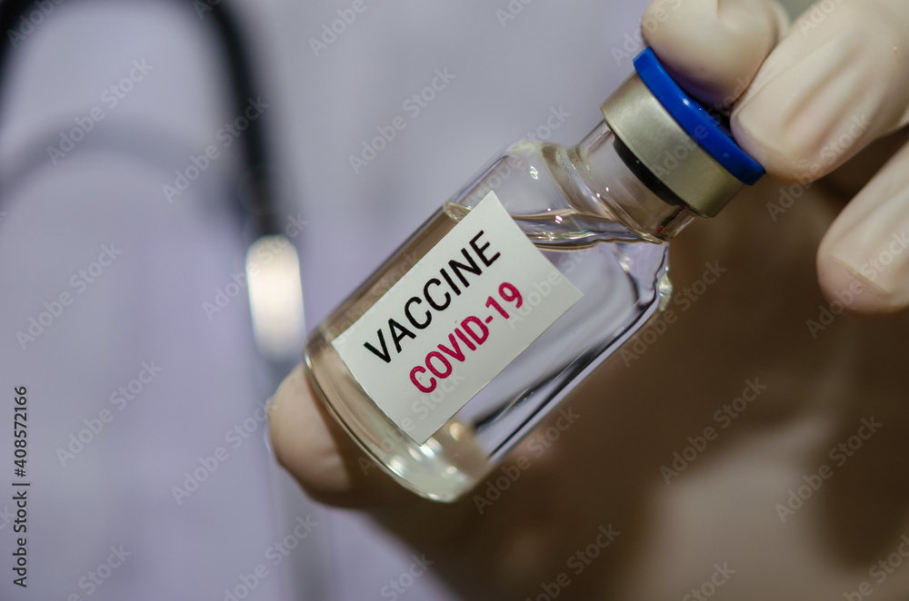 Male doctor holding a bottle of COVID-19 vaccine medicine Or the coronavirus vaccine