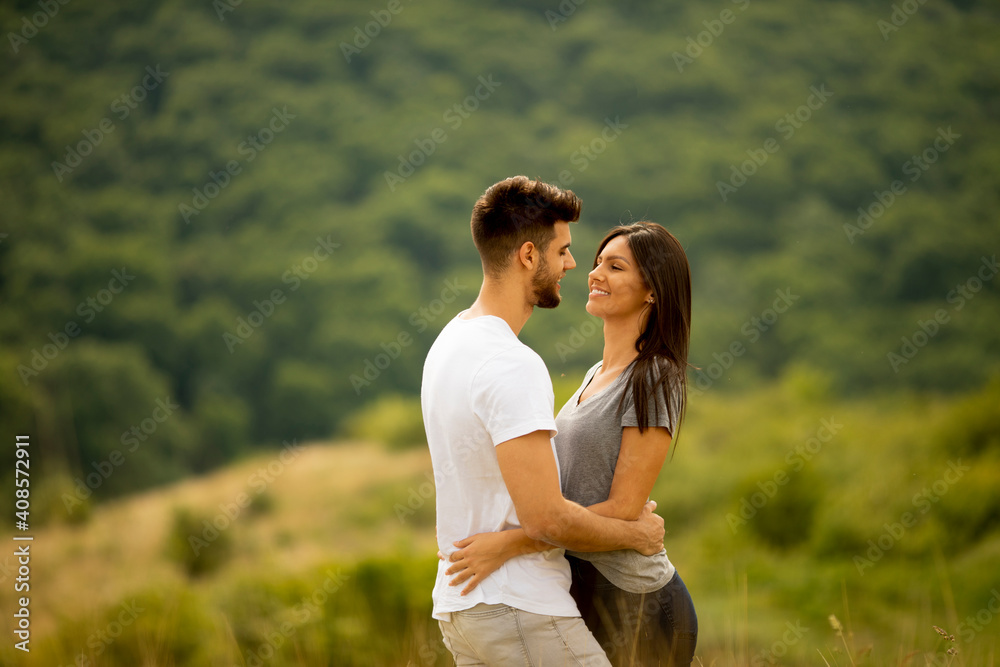 Happy young couple in love at the grass field