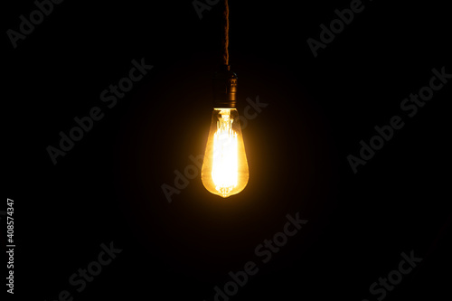 Decorative antique edison style light bulb glowing in the dark. Interior bulb.