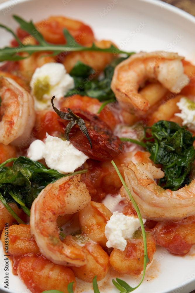 Gnocchi with shrimp and baked tomatoes. Italian seafood