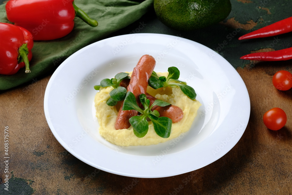 Sausages with mashed potatoes on a dark wooden background. Sausages with mashed potatoes on a dark wooden background.