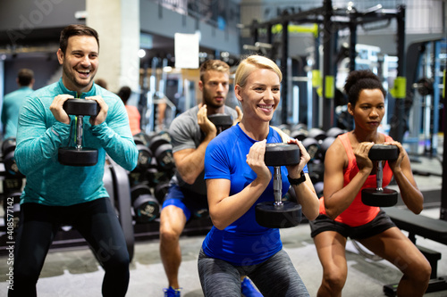 Group of sportive people in gym. Happy fit friends workout, exercise in fitness club