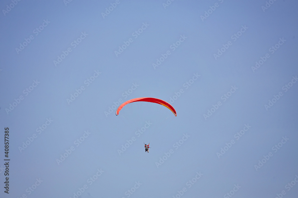 Paragliding in the sky. Paraglider flying in bright sunny day. Beautiful paraglider in flight on a turquise background. Paragliding in the sky. Paraglider flying in bright sunny day. Beautiful paraglider in flight on a turquise background.