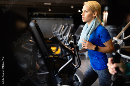 Attractive fit young woman using a step machine in the gym