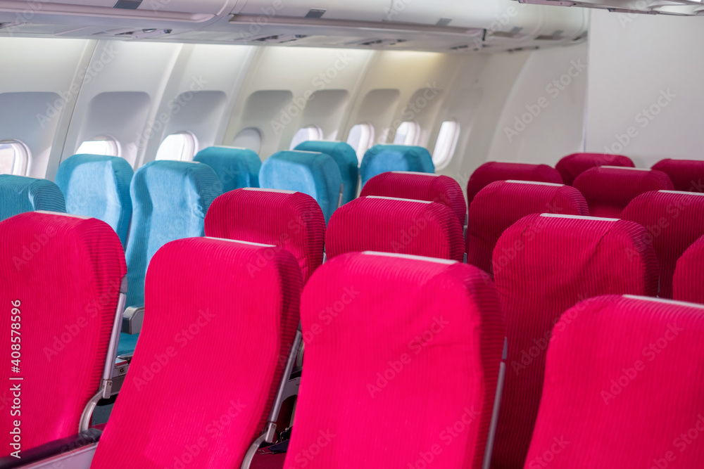 Fototapeta premium Empty passenger seat in the economy class of airplane in the cabin. Interior of airplane with walking the aisle. Slow motion.
