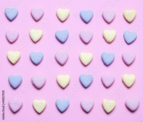 Top view flat lay pastel hearts on a pastel pink background. Romantic seamless pattern for prints and posters.