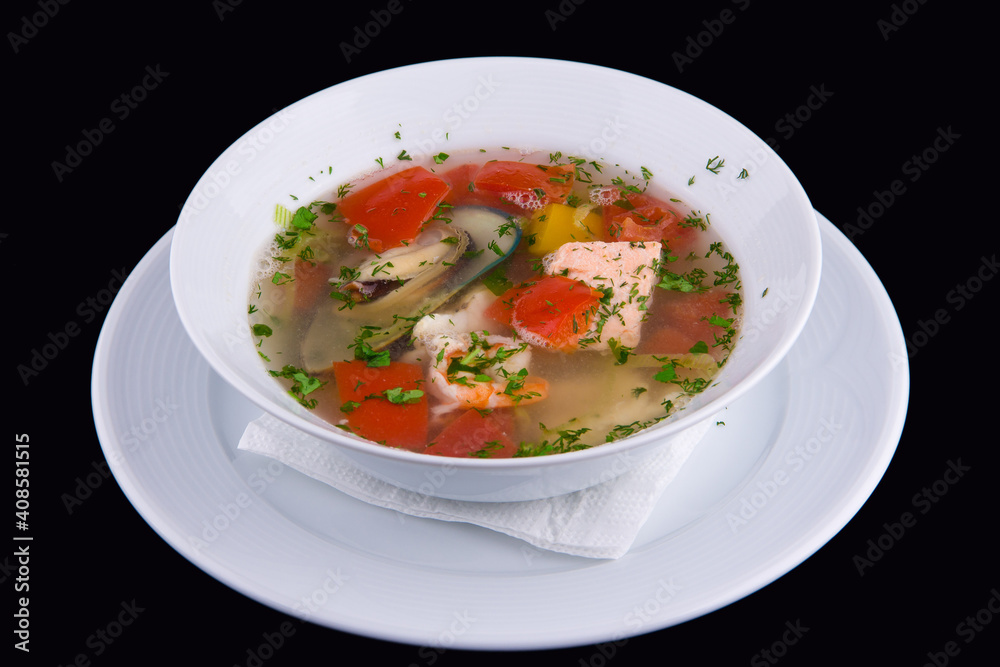 Ukha - fish soup with salmon slices, shrimp and mussels with red bell pepper