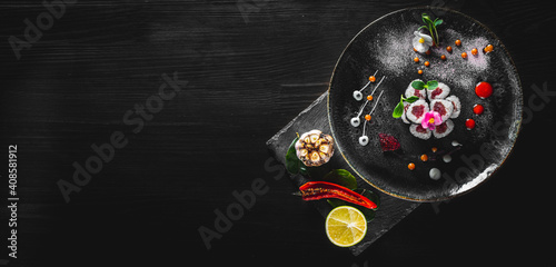 sushi roll with tuna and rice in plate on black wooden table background
