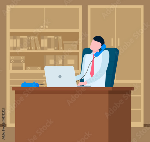 Young man dressed formally talking on the phone. Businessman working at the computer sitting at a table in office space. Manager doing work on the laptop. Serious man communicates and takes notes