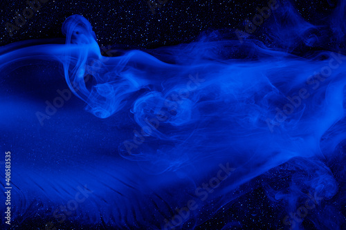 Abstract blue smoke moves on black background. Beautiful swirling smoke.