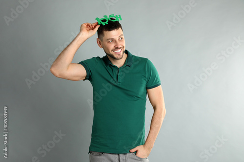 Canvas Print Happy man in green shirt and party glasses on light grey background