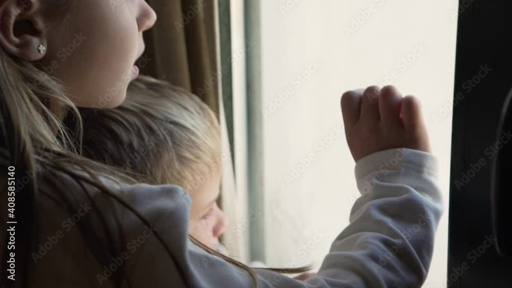 Adorable siblings looking through window and communicating Adorable siblings looking through window and communicating