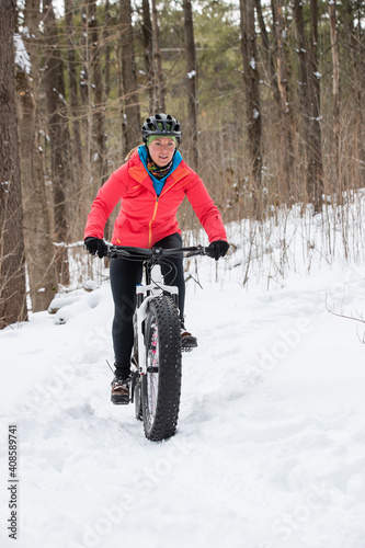 Attractive woman rides her fat bike in the snow