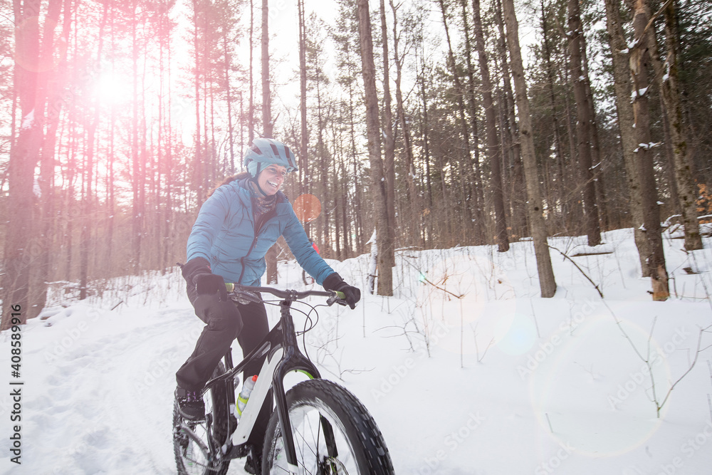 Attractive woman rides her fat bike in the snow