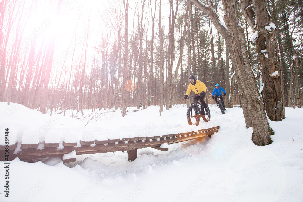 Attractive couple riding fat bikes in the snow