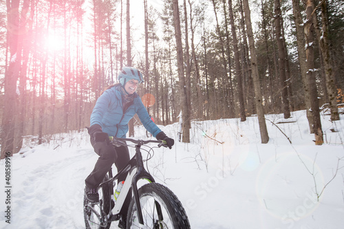 Obraz na płótnie Attractive woman rides her fat bike in the snow w salonie
