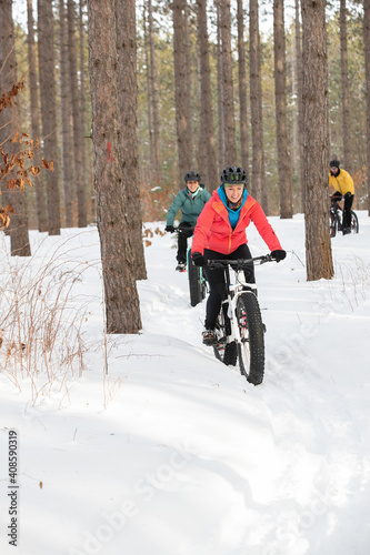 Obraz na płótnie Group of attractive women riding fat bikes in the snow w salonie