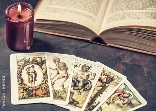 Tarot cards with candlelight and book on the darkness background,Halloween and future reading concept.